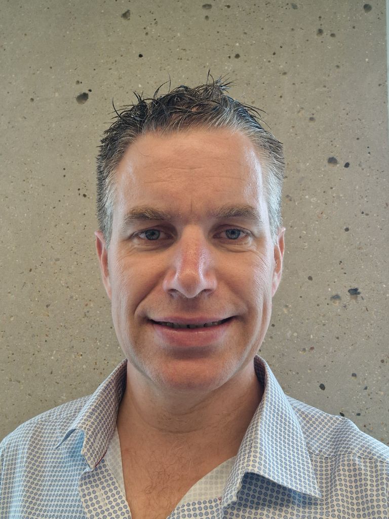 Peter McShane - Professional headshot in light blue patterned shirt